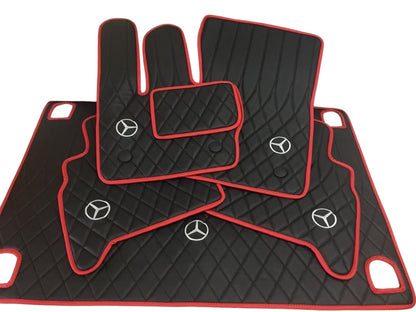 A set of black floor mats with red trim for a Mercedes-Benz G Wagon, including a logo emblem on the front mat.