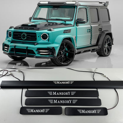 Matte black door sills with 'MANSORY' branding on them, designed for a Mercedes-Benz G-Class, alongside the vehicle they belong to.
